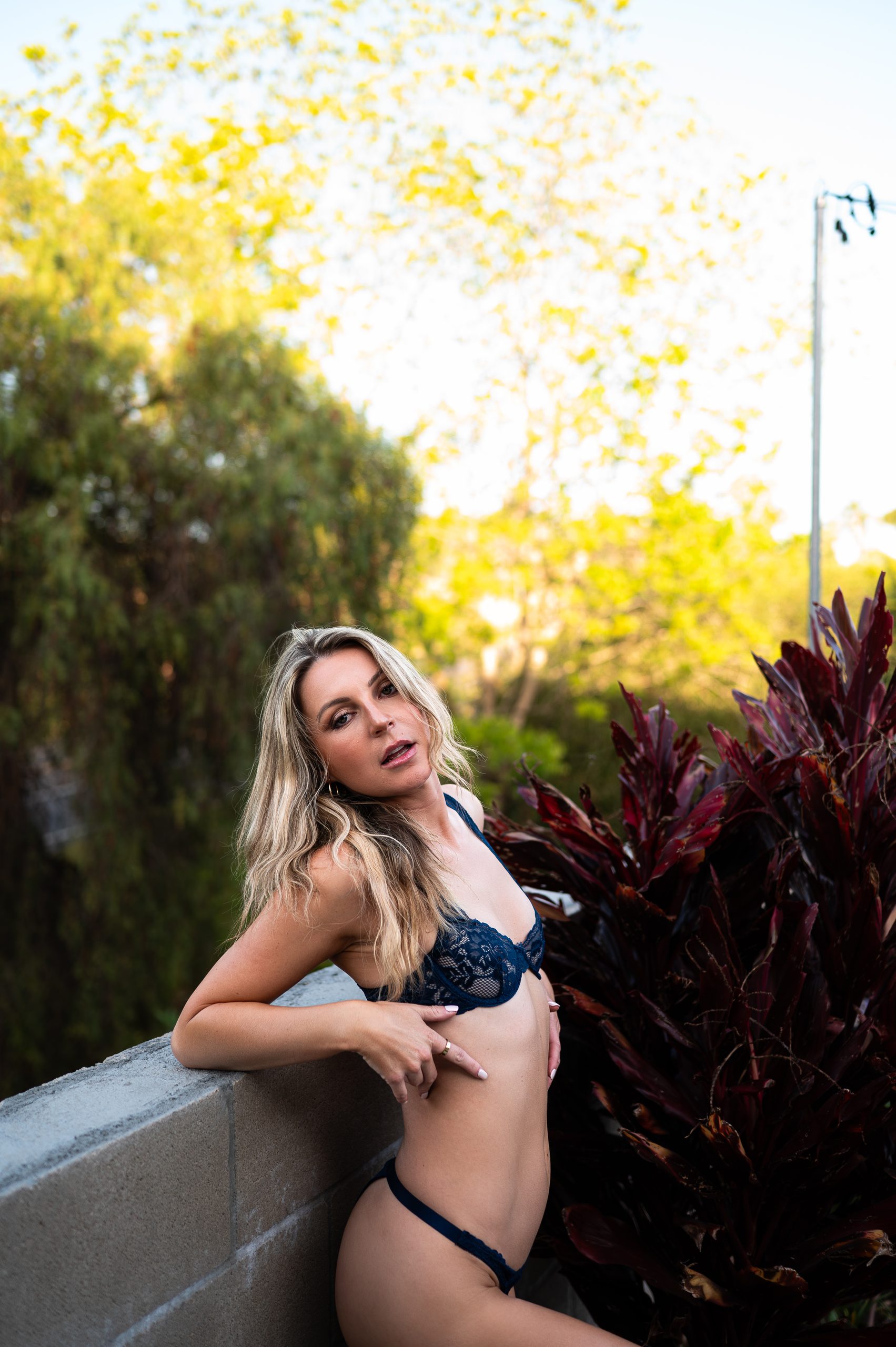 traditional lace bra and panty set. This is an outdoor photograph of a client leaning against a wall.