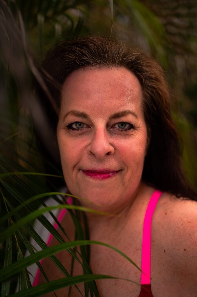 This photograph is a close up of a 60 year old woman with blue eyes. Self love can be worked on at any age. We are all deserving of a positive relationship