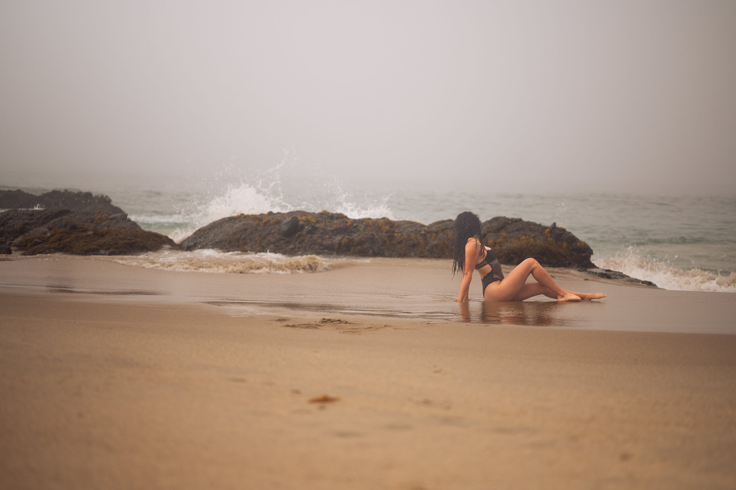 ELI Boudoir Luxury boudoir photography in Los Angeles. This photograph showcases a woman posing on Thousand Steps beach in a black bodysuit.