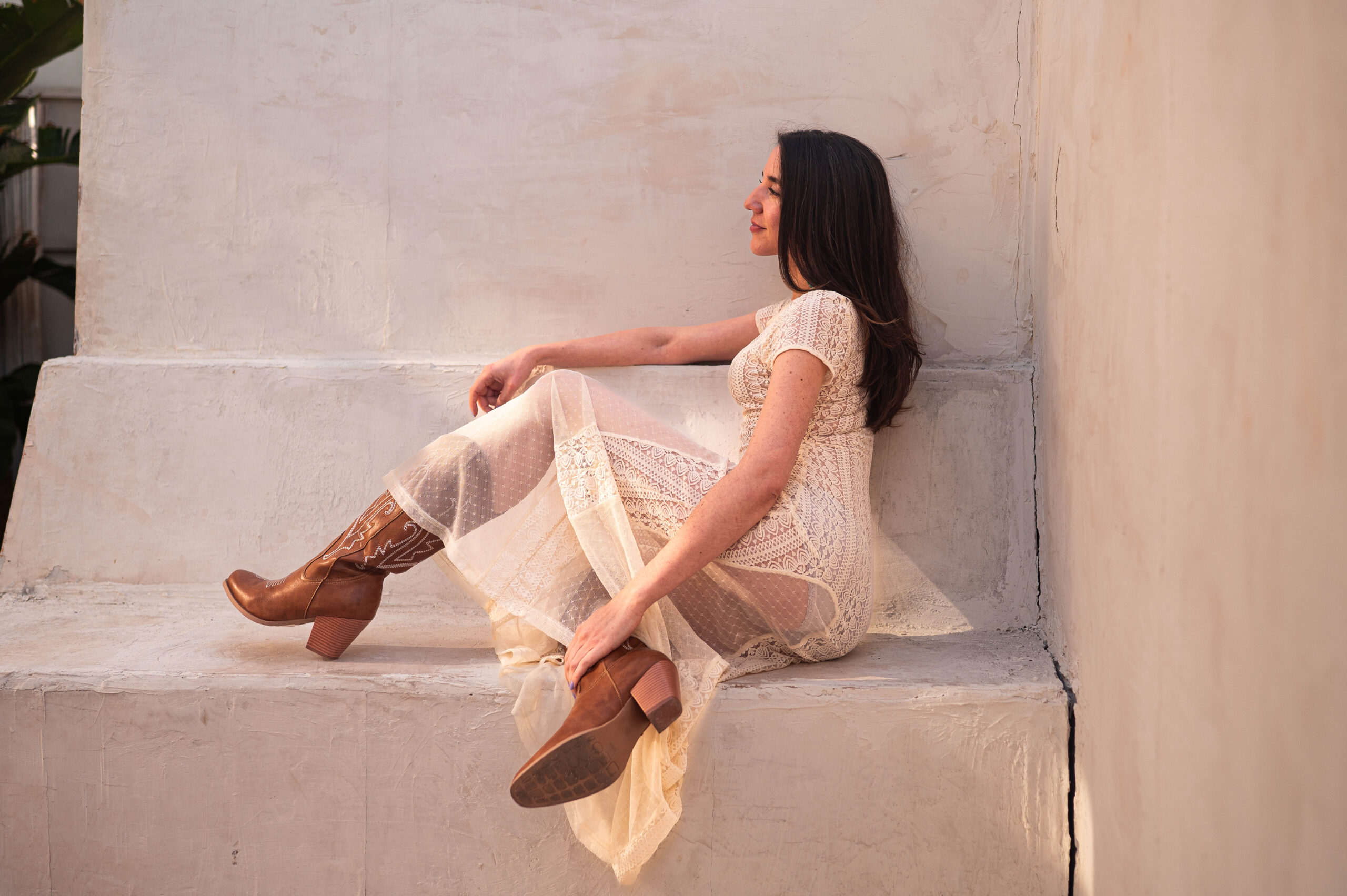 ELI Boudoir Luxury boudoir photography in Los Angeles. This image showcases a beautiful white dress and cowboy boots as an example for the best boudoir lingerie for every skin tone. 