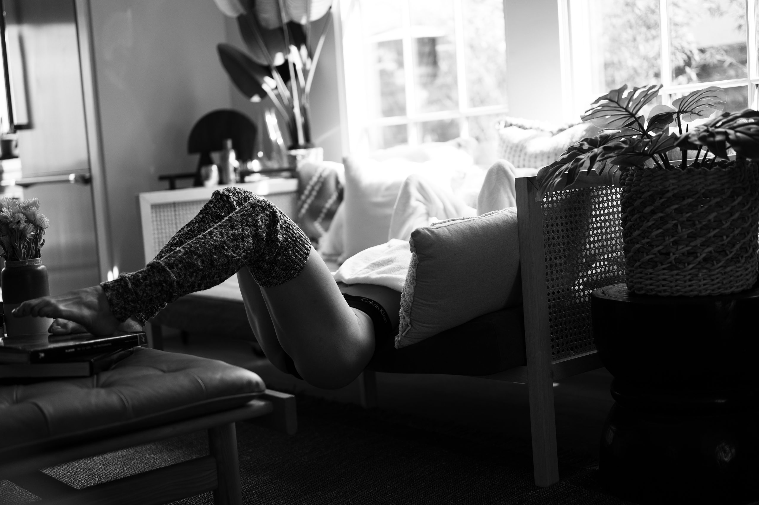 Woman posing comfortably during a professionally guided boudoir session